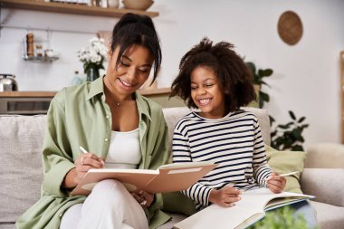 A mother and her little daughter enjoy a joyful afternoon, drawing and bonding together. clipart