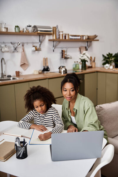 Любящая мать поддерживает свою дочь, исследуя творческую деятельность за их домашним столом..