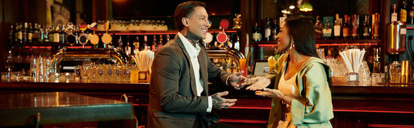 A young multicultural couple shares laughter and conversation at a lively bar on a night out.