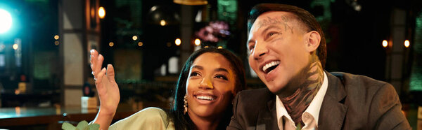 A young couple shares laughter and joy during a vibrant evening date at a bar.
