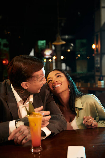 A young couple shares laughter and joy during their exciting night out at the bar.
