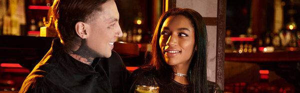 Татуированные мужчина и женщина делятся улыбками, наслаждаясь напитками во время их романтического вечера, баннер