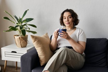 A young woman relaxes in her stylish apartment, sipping coffee and enjoying daylight. clipart