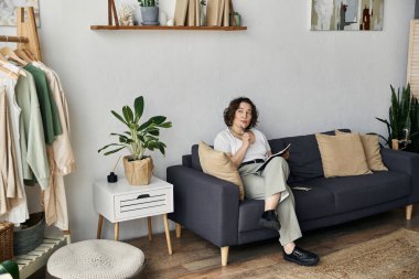 Modern dairesine kıvrılan genç bir kadın gün boyunca yaratıcı ilhamı kucaklıyor..