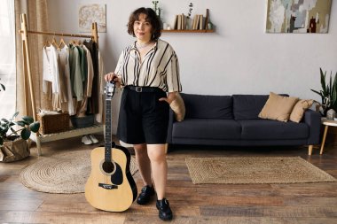 Parlak ve davetkar, bu genç bayan rahat dairesinde duruyor, elinde gitarıyla..