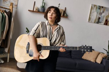 Güzel bir kadın şık dairesinde gitar çalar, sanatsal yaşam tarzını benimser..