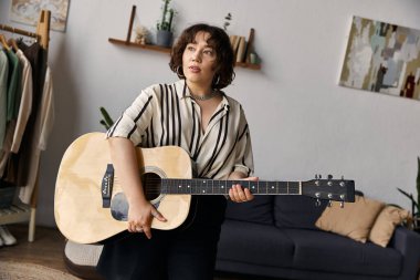 Beautiful woman plays guitar in her stylish apartment, embracing her artistic lifestyle. clipart