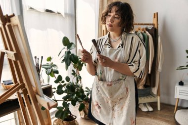 Kıvırcık saçlı sanatçı, şık dairesinde tutkuyla güzel bir sanat eseri yaratıyor..