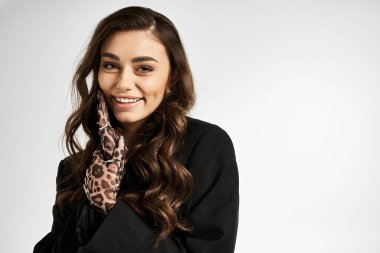 Çekici kadın moda kıyafetlerini ve neşeli ifadesini kapalı mekanda sergilerken mutluluk saçıyor.