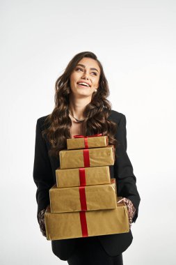 Cheerful lady enjoys carrying stylishly wrapped presents with bright red ribbons. clipart