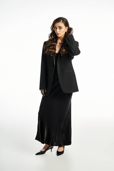 Стильная женщина демонстрирует черный ансамбль, излучая грацию и уравновешенность, обнимая свою красоту..