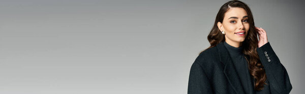 Очаровательная молодая женщина излучает уравновешенность и изящество, улыбаясь, демонстрируя свое чувство стиля.