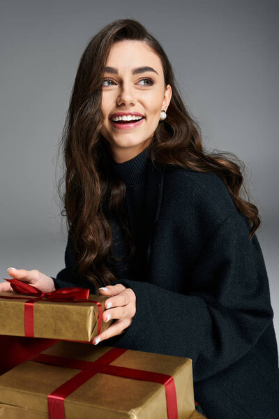 Светлые глаза молодая женщина с длинными волосами наслаждается праздничной атмосферой, держа подарки.
