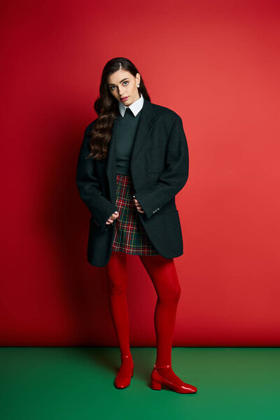 Pretty woman showcases a fashionable outfit with striking colors in a bold, artistic setting.