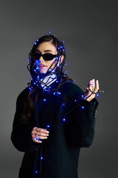 Молодая женщина обнимает свой стиль, игриво завернутый в голубые огни феи.