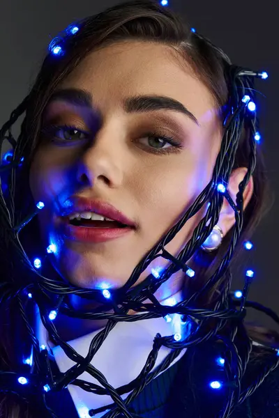 Genç bir kadın mavi ışıkta parlıyor, sanatsal bir güzellik yayıyor..