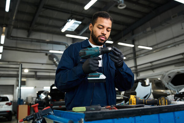 Dedicated young mechanic focuses intently on fixing tools in a vibrant garage setting
