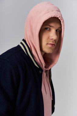 Genç adam kendine güvenerek duruyor, eşsiz moda anlayışını sergiliyor..