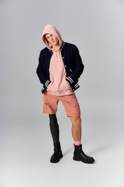 Genç adam son moda sokak kıyafetleri giyerken protez bir bacakla rahatça poz veriyor..