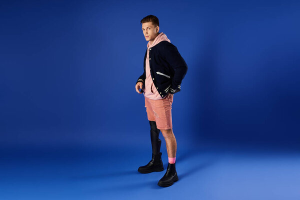 Handsome young man wears stylish outfit showcasing his prosthetic leg in a vibrant setting.