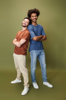 İki arkadaş sırt sırta durur, gülümser ve benzersiz tarzlarını sergilerler, çeşitliliği kucaklarlar..