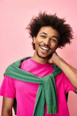 A cheerful queer person smiles brightly, showcasing their colorful outfit against a pink backdrop. clipart