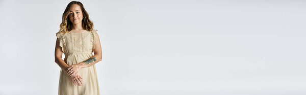 Молодая женщина с потрясающим витилиго уверенно выставляет напоказ свою красоту в светлом платье.