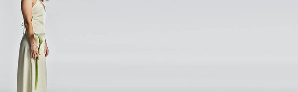 Молодая женщина с витилиго элегантно стоит в минималистском пространстве, демонстрируя свою красоту.