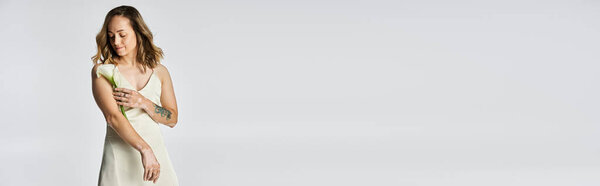 A young woman with vitiligo gracefully holds a flower, showcasing her beauty and confidence.