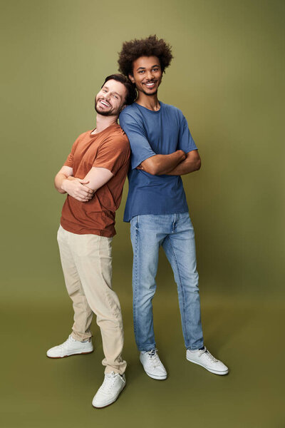 Два друга стоят спиной к спине, улыбаясь и демонстрируя свои уникальные стили, принимая разнообразие.