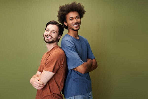 Two friends stand back to back, beaming with happiness in a colorful, inclusive atmosphere.