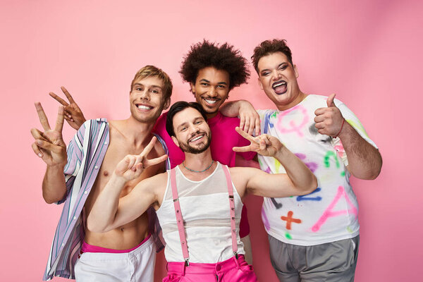 Four joyful individuals pose in brightly colored outfits, showcasing their pride and vibrancy.