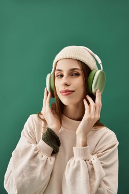 A young woman enjoys music while wearing headphones, portraying her unique style and confidence. clipart