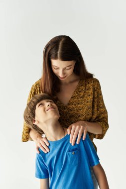 Parlak bir stüdyoda, genç bir anne oğluna gülümser ve sevgi dolu bir bağ kurar..