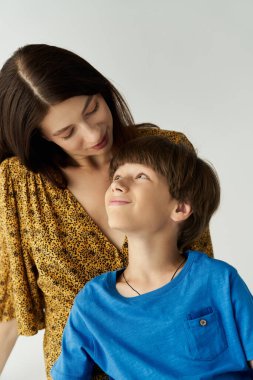 Genç bir anne ve oğlu, sevgi ve bağın göstergesi olarak, yürek ısıtan bir anın tadını çıkarırlar..