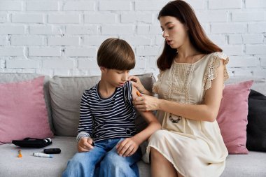 Genç anne, oğlunun rahat oturma odasında insülin iğnesine yardım ediyor..