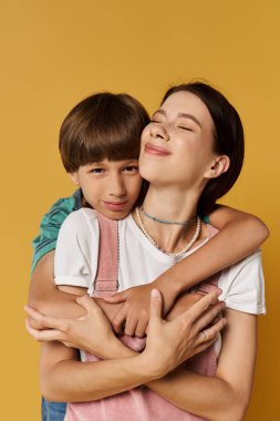 Bir anne ve oğul sıcak, neşeli bir bahçede sevgi dolu bir kucaklaşmayı paylaşıyor..