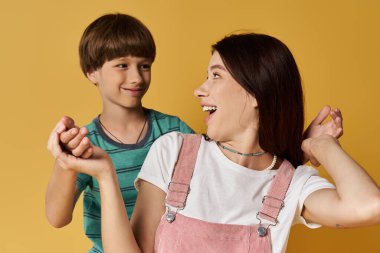 A young mother and her son share a candid moment, filled with laughter and love in a bright studio. clipart