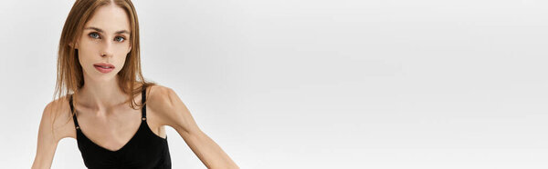 Young woman struggling with anorexia poses confidently in a subtle, modern environment.