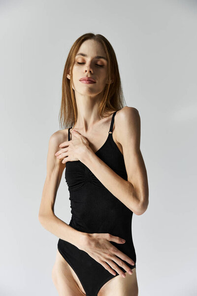 A young woman expresses her struggle with anorexia through a serene pose in a studio setting.