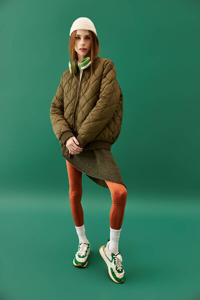 A young woman with anorexia presents her unique fashion sense in a bright green environment.