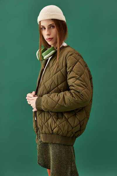 A young woman with anorexia stands confidently against a green backdrop, reflecting her struggle.