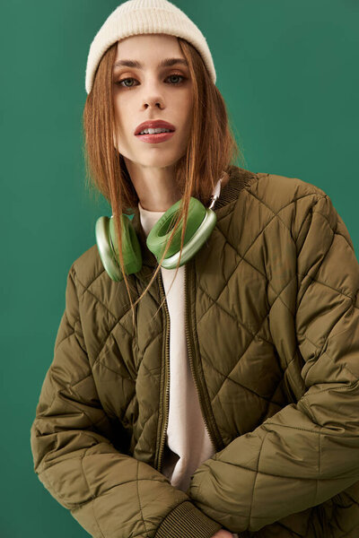 Young woman with anorexia poses confidently against a green backdrop, showcasing her beauty.