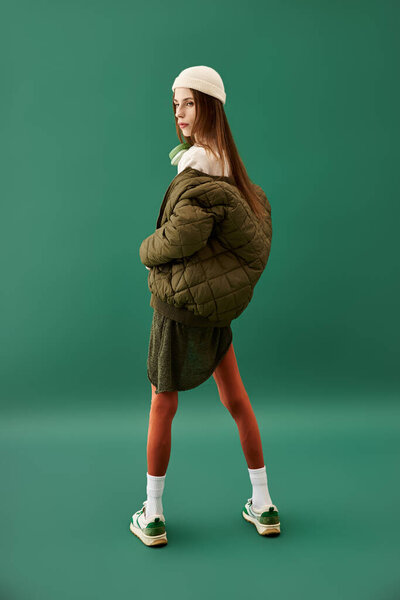 Young woman with an eating disorder displays a striking outfit amid a simple backdrop.