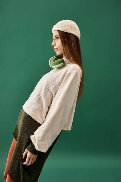 A young woman with anorexia poses confidently against a green background, showcasing strength.