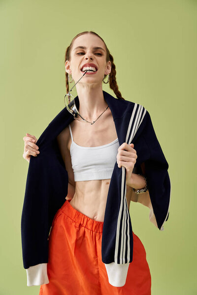 Молодая женщина борется с анорексией, уверенно позируя на зеленом фоне