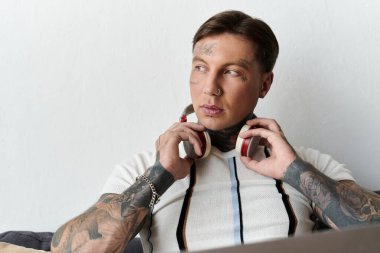 Dövmeli yakışıklı genç adam evde dinlenirken müziği seviyor..