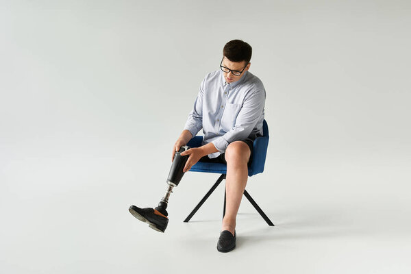 Молодой красивый мужчина приспосабливает свою протезную ногу, сидя в кресле.