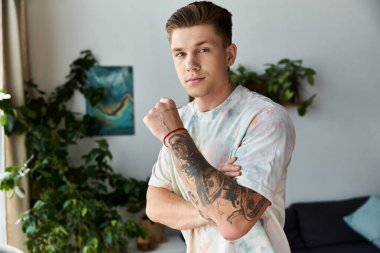 Kendine güvenen genç adam yeşilliklerle dolu şık bir odada duruyor..