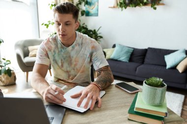 A young man is focused on his work at a bright, cozy home office setting. clipart